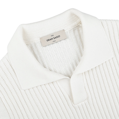 Close-up of an off-white, slim fit ribbed knit polo shirt with a collar and an inner label reading "Gran Sasso," made from soft organic cotton for unmatched comfort.