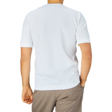 A person facing away from the camera wearing a Gran Sasso Off-White Organic Cotton T-shirt and brown trousers.
