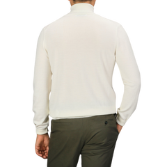 A person wearing an off-white Gran Sasso Extra Fine Merino Roll Neck and dark green pants is shown from the back.