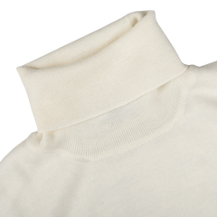 Close-up image of an Off White Extra Fine Merino Roll Neck by Gran Sasso, showing the neckline and part of the upper shoulder.