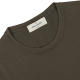 Close-up of an olive green organic cotton t-shirt's collar with a Gran Sasso brand label.