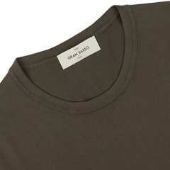 Close-up of an olive green organic cotton t-shirt's collar with a Gran Sasso brand label.