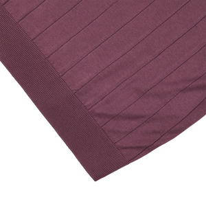 A close up of a lightweight Gran Sasso plum colored silk blanket.