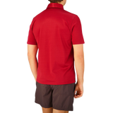 The back view of a man wearing a Raspberry Red Cotton Filo Scozia polo shirt by Gran Sasso.