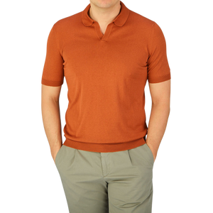 A man wearing a Gran Sasso Rust Orange Knitted Silk Polo Shirt and khaki pants.