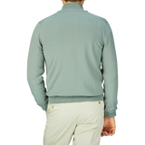 A man seen from behind wearing a slim fit, sage green Gran Sasso Egyptian Cotton 1/4 Zip sweater and light-colored pants.