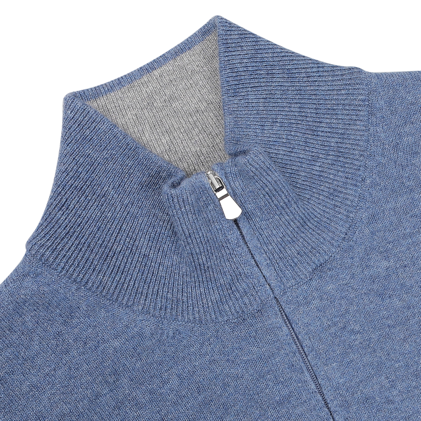 A close-up of the Gran Sasso Sky Blue Cashmere 1/4 Zip Sweater showcases its ribbed zip-up design and high collar, complete with a metal zipper pull. This premium knitwear piece is accented by a contrasting gray lining for enhanced style.