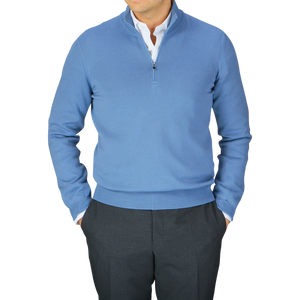 A man in a Sky Blue Egyptian Cotton 1/4 Zip sweater by Gran Sasso and dark trousers against a neutral background.