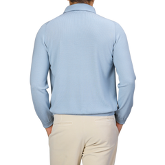 A person wearing a Sky Blue Merino Wool One-Piece Collar Polo Shirt from Gran Sasso and beige pants, viewed from the back.