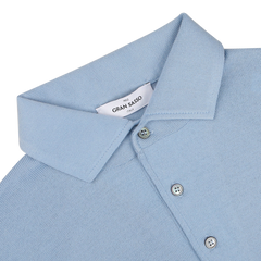 This sky blue merino wool polo shirt from Gran Sasso boasts a one-piece collar with two buttons fastened and a visible tag emblazoned with the brand name.