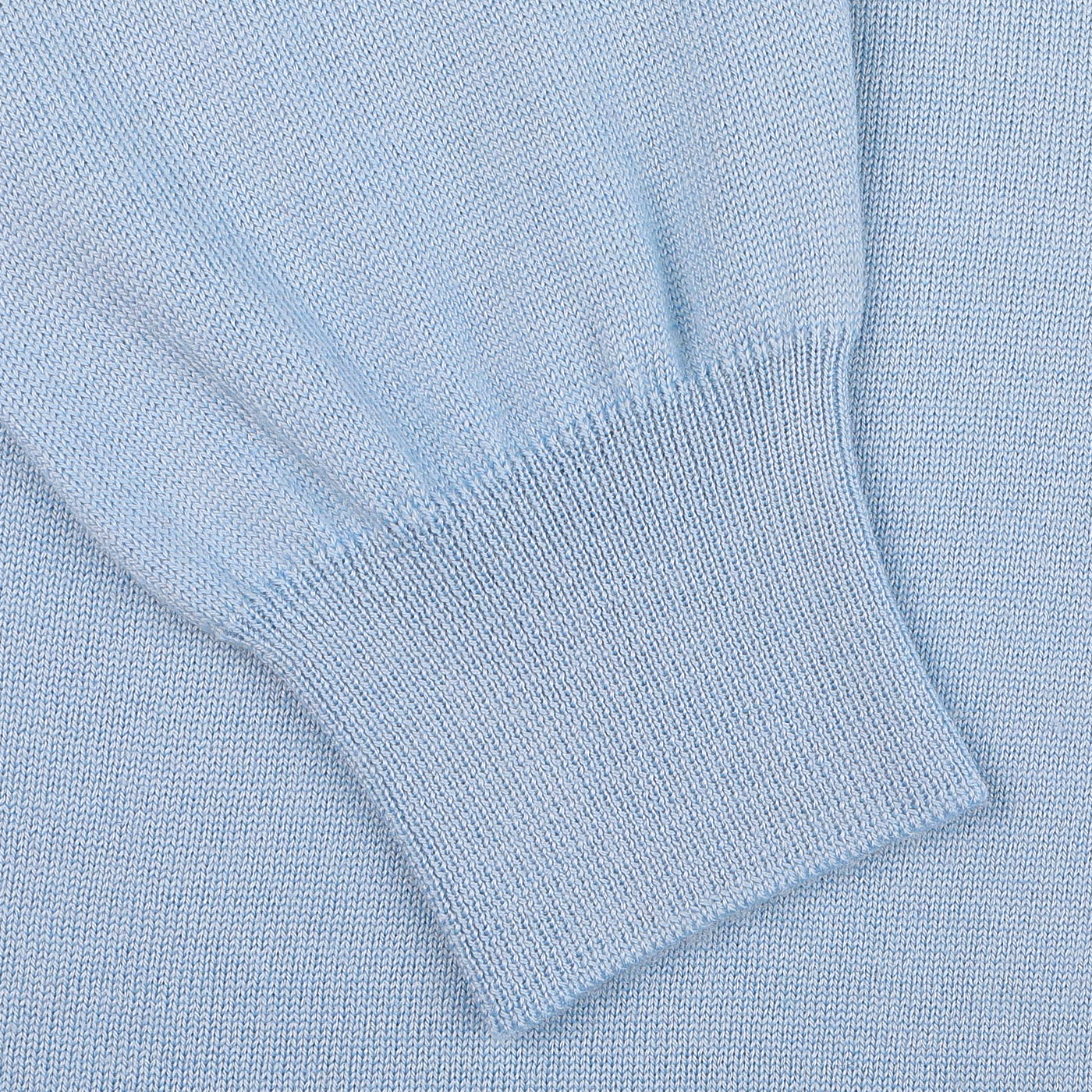 Close-up of a Sky Blue Merino Wool One-Piece Collar Polo Shirt sleeve laid flat, crafted by Gran Sasso, highlighting the fabric's texture and ribbed cuff.