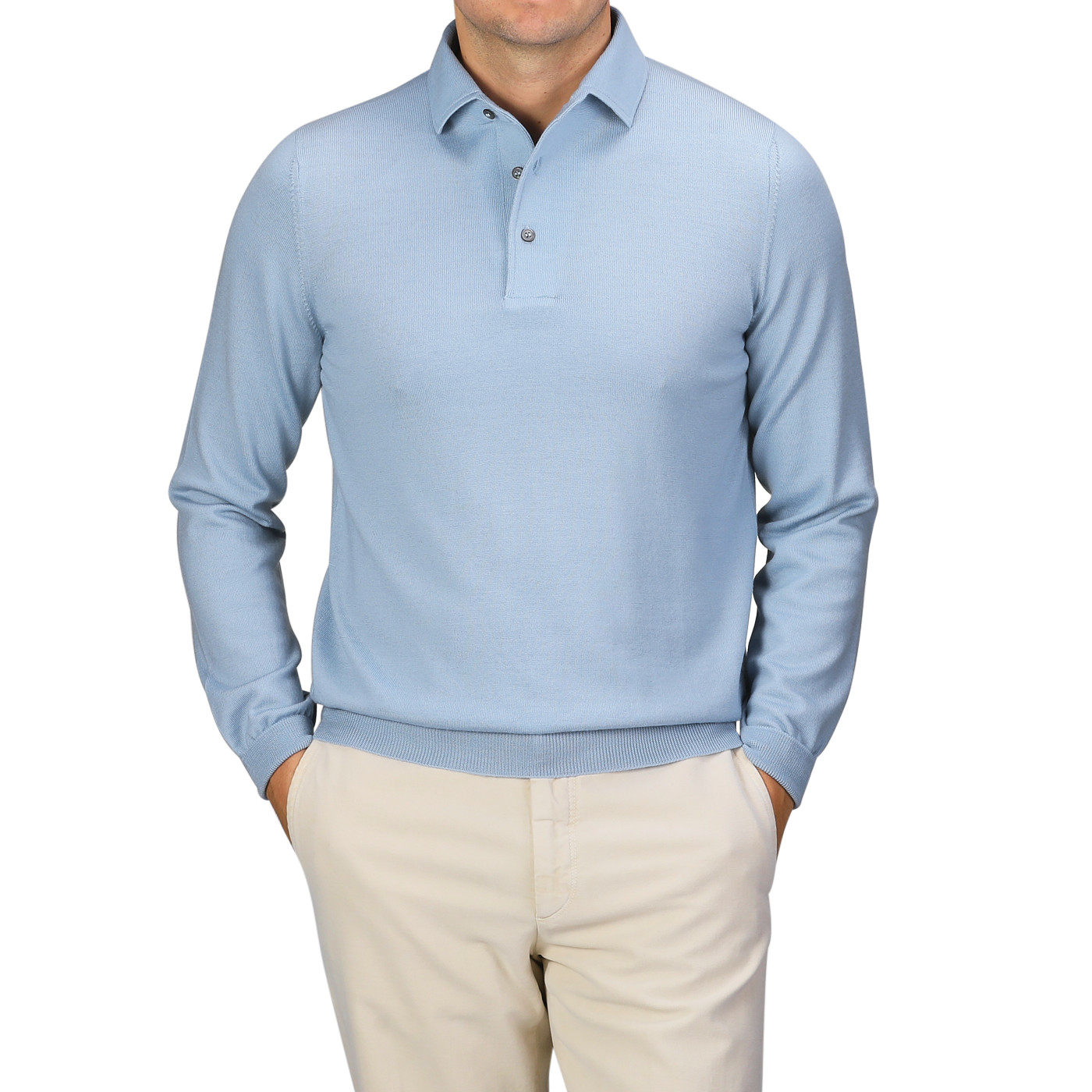 Against a plain gray backdrop, a man stands with his hands in his pockets, wearing the Gran Sasso Sky Blue Merino Wool One-Piece Collar Polo Shirt paired with beige pants.