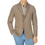 A man wearing a Gran Sasso Taupe Brown Cotton Linen Knitted Blazer and slim fit blue pants.