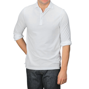 A person wearing a Gran Sasso White Washed Cotton Popover Shirt with rolled-up sleeves and dark jeans stands against a gray background.