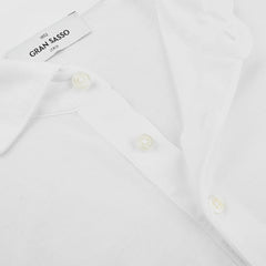 Close-up of a white Gran Sasso White Washed Cotton Popover Shirt in jersey, showcasing three buttons, its collar, and a tag labeled "Gran Sasso, Italy.