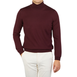 A man wearing a Wine Melange Extra Fine Merino Roll Neck sweater by Gran Sasso in super soft extra fine wool.