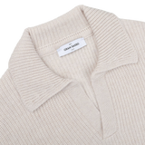 Close-up of an Ecru Beige Chunky Knit Wool Polo Shirt by Gran Sasso, made from super Geelong wool, featuring a folded collar and a label inside that reads "Gran Sasso.