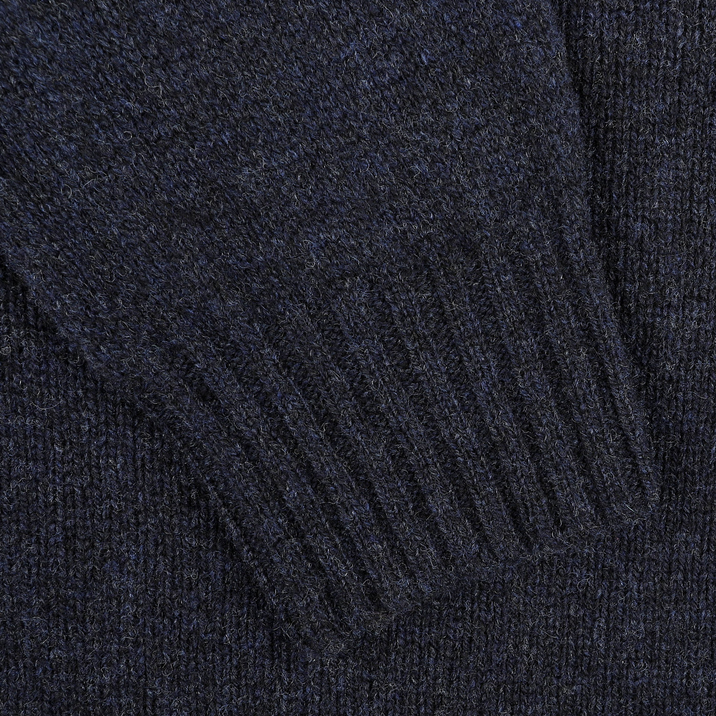 Close-up of the sleeve of a Cosmos Blue Extrafine Lambswool Rollneck by Harley of Scotland, showcasing its dark navy blue knit with ribbed cuff detail.