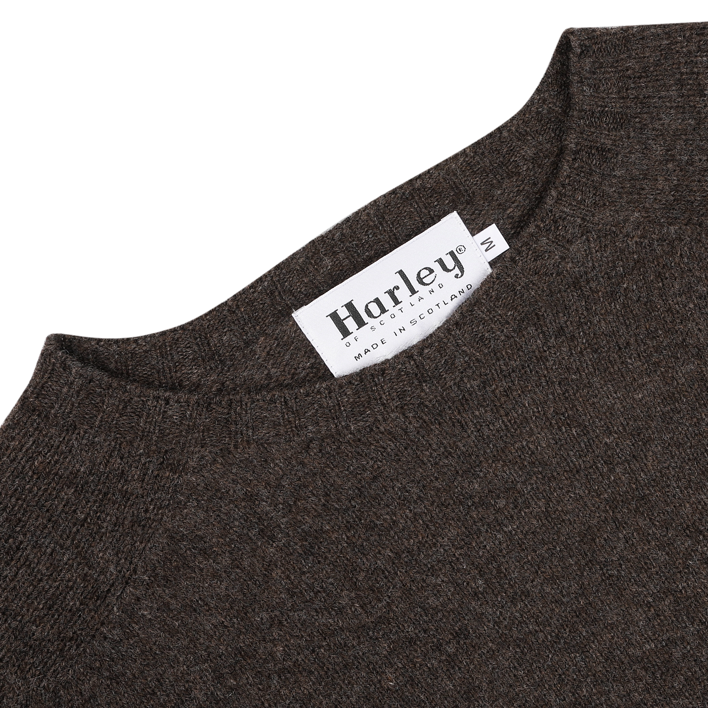 Close-up of the Porcupine Brown Extrafine Lambswool Crewneck, featuring a white tag labeled "Harley of Scotland," highlighting the craftsmanship of this renowned Scottish knitwear specialist.