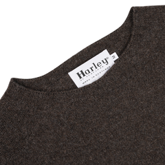 Close-up of the Porcupine Brown Extrafine Lambswool Crewneck, featuring a white tag labeled "Harley of Scotland," highlighting the craftsmanship of this renowned Scottish knitwear specialist.