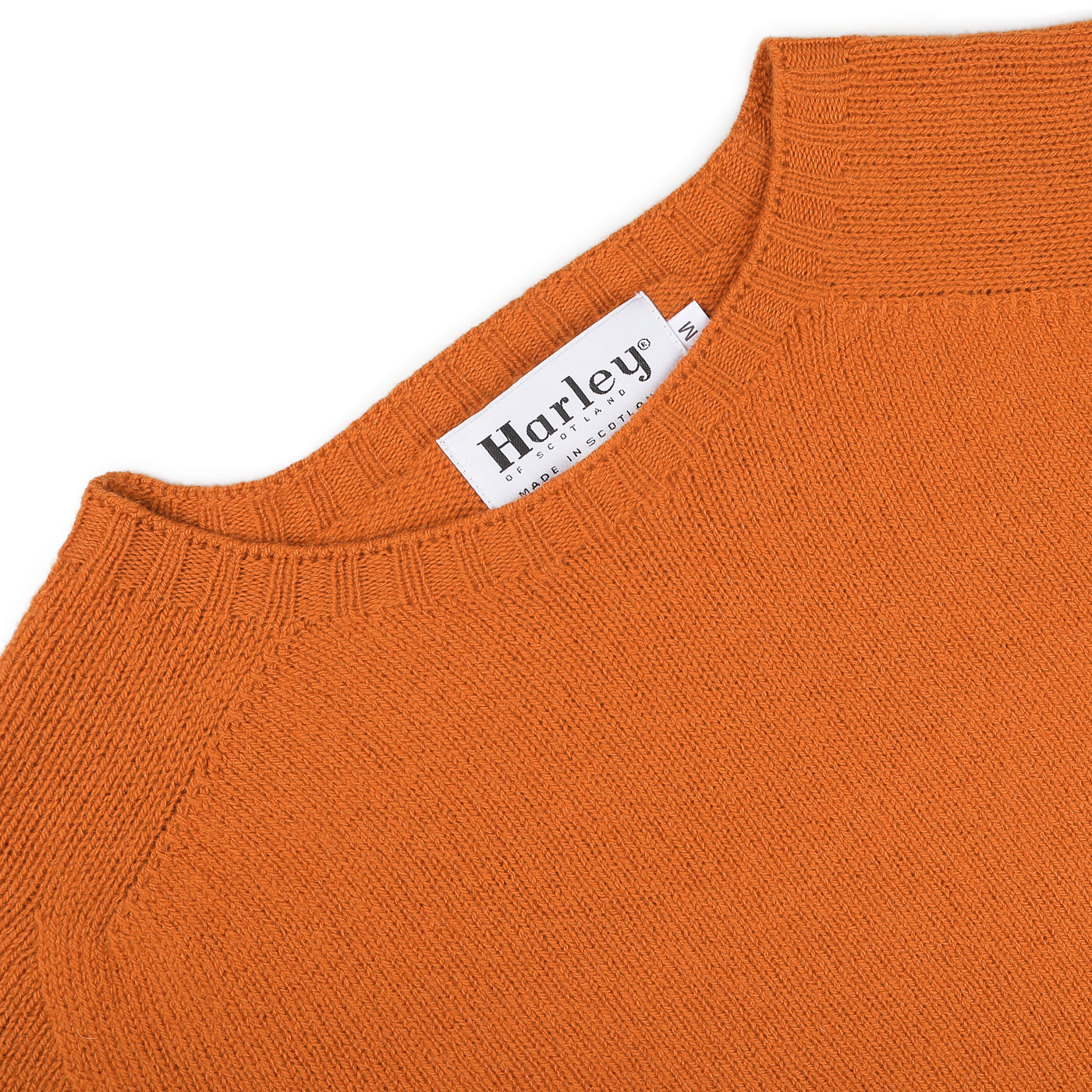 A Sienna Orange Extrafine Lambswool Crewneck with a "Harley of Scotland" label at the neckline, highlighting knitwear craftsmanship.