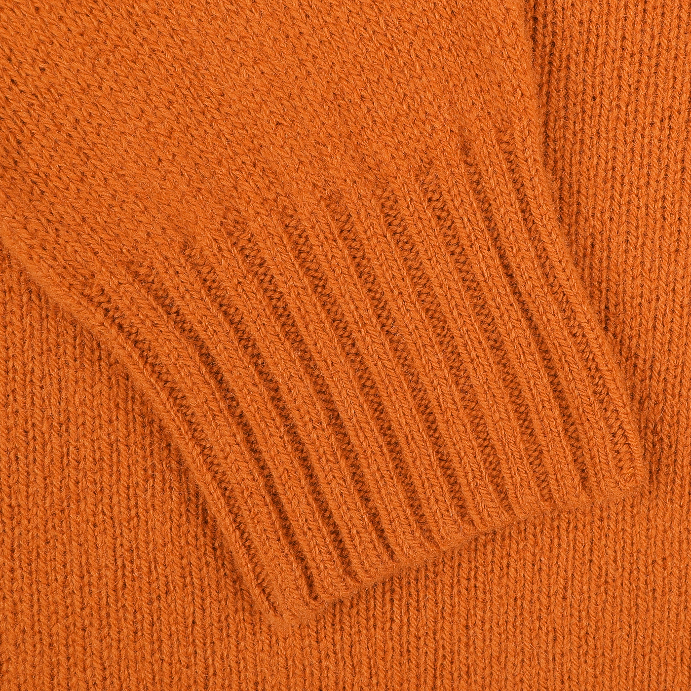 A close-up of the Harley of Scotland Sienna Orange Extrafine Lambswool Crewneck sweater showcases the ribbed cuff detail, highlighting their knitwear specialist expertise.