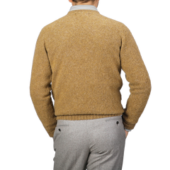 A person wearing an Asparagus Brushed Shaggy Wool Crewneck by Harley of Scotland and gray pants is shown from the back.