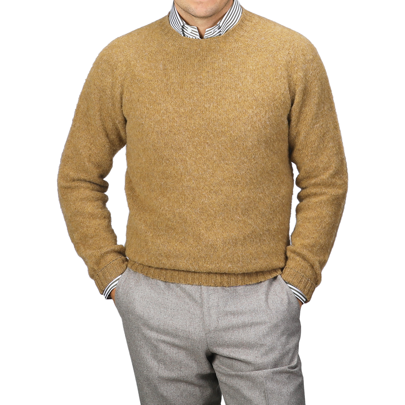 A person wearing the cozy Asparagus Brushed Shaggy Wool Crewneck by Harley of Scotland stands with hands in pockets, layered over a striped shirt and paired with gray pants.