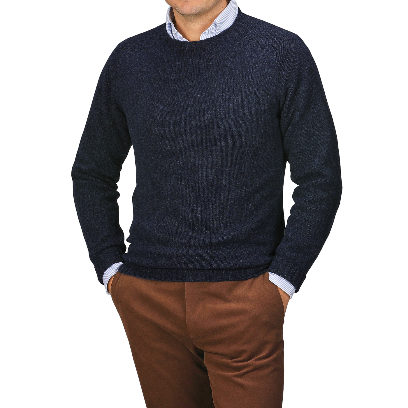 A person stands with hands in pockets, wearing a Harley of Scotland Cosmos Blue Extrafine Lambswool Crewneck over a light shirt and brown pants, set against a neutral background.