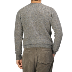 A person clad in a cozy Oyster Grey Brushed Shaggy Wool Crewneck sweater and brown corduroy pants, possibly from Harley of Scotland, is shown from the back against a plain background.