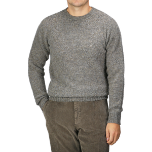 A person wearing the Oyster Grey Brushed Shaggy Wool Crewneck by Harley of Scotland and brown corduroy pants stands against a plain background.