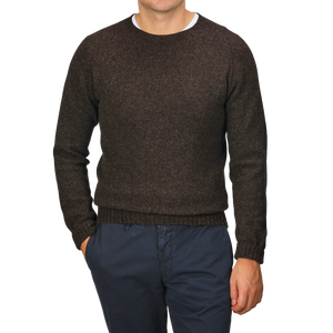 A person wearing a Porcupine Brown Extrafine Lambswool Crewneck by Harley of Scotland and navy pants stands against a neutral background.