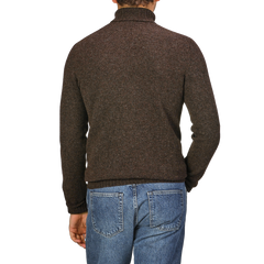 Back view of a person wearing the Porcupine Brown Extrafine Lambswool Rollneck and blue jeans, showcasing luxurious knitwear from Harley of Scotland.