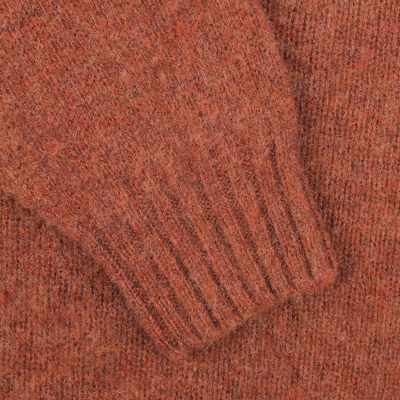 Close-up of a textured sleeve from the Sienna Brushed Shaggy Wool Crewneck by Harley of Scotland, featuring a ribbed cuff crafted using a seamless knitting technique.