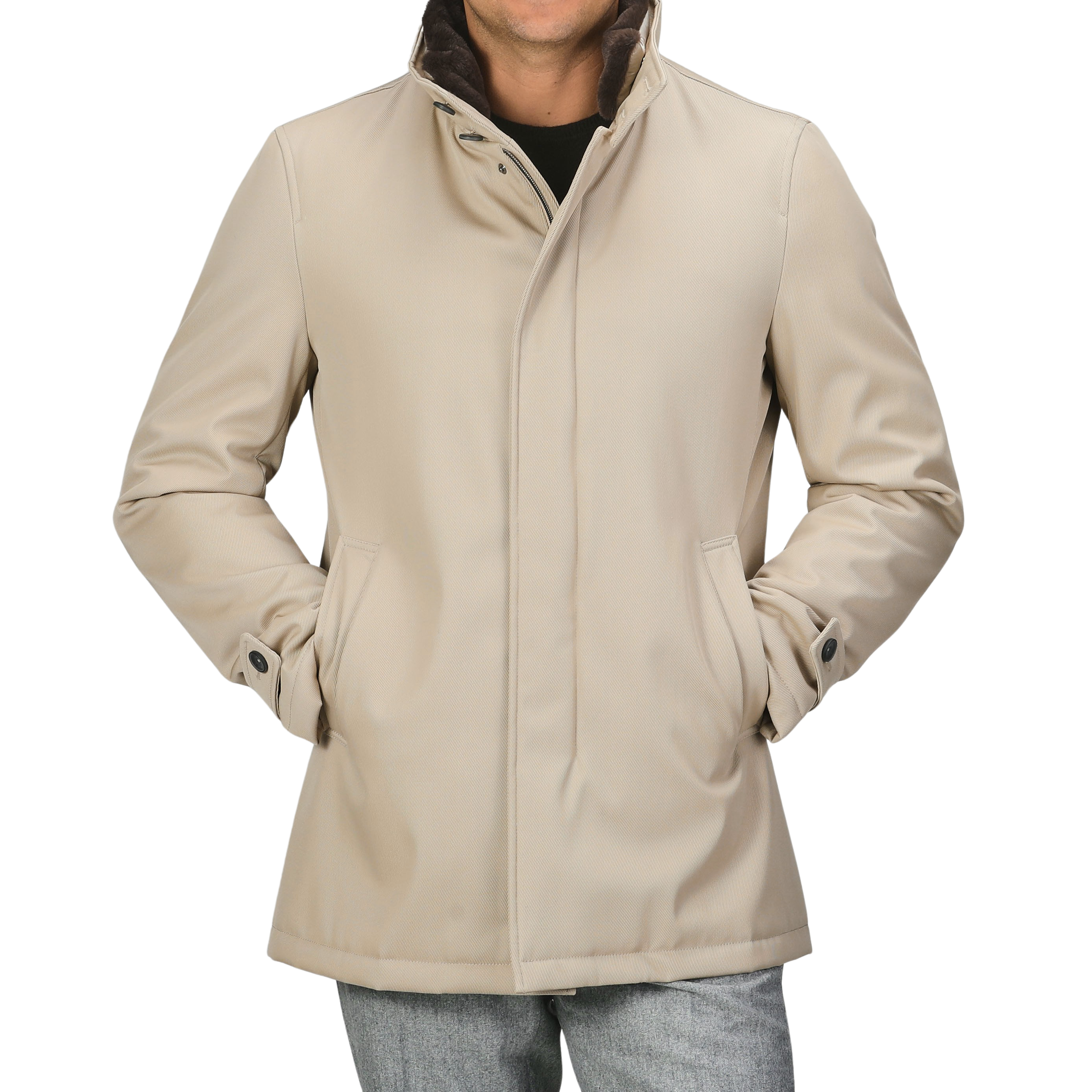 A person wearing a luxurious Beige Loro Piana Wool Twill Jacket by Herno with hands in pockets, over a black shirt and grey pants. The pure wool twill jacket features a high collar, button details on the cuffs, and offers both rain and wind resistance.