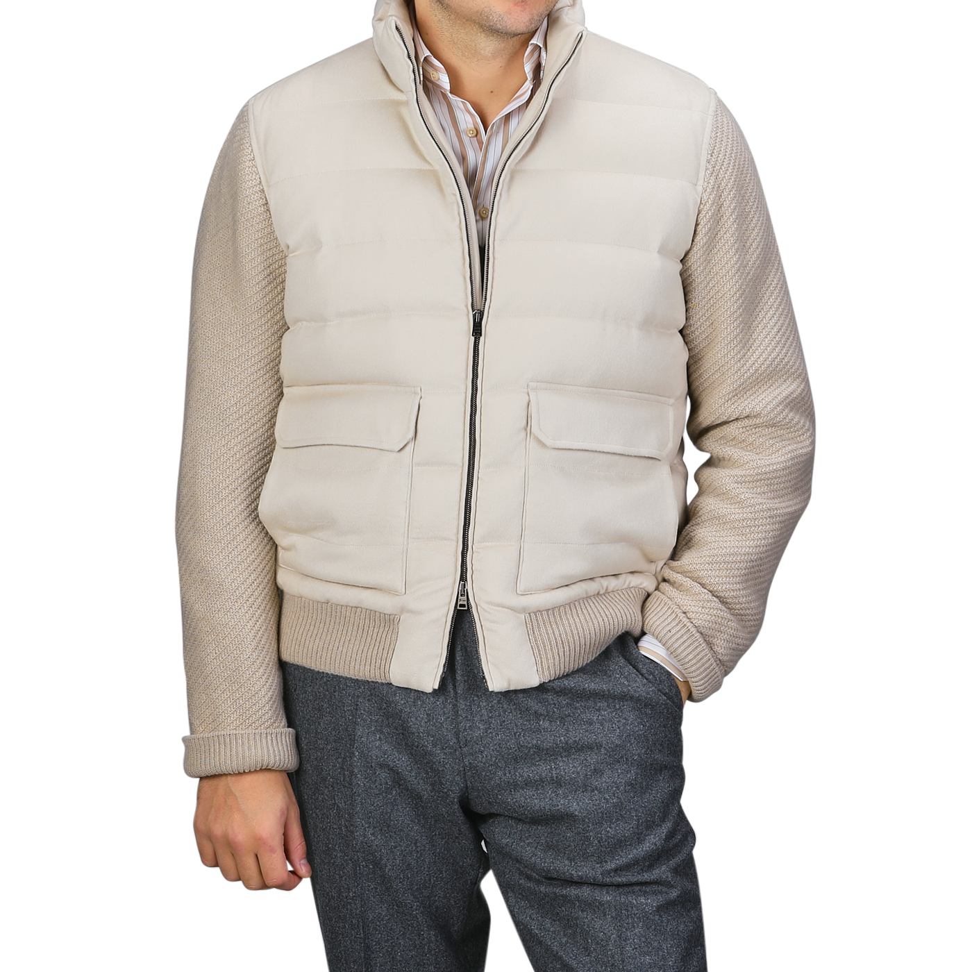 A person wearing a Herno Cream Beige Cashmere Silk Bomber Jacket over a striped shirt and gray pants stands with one hand in their pocket.