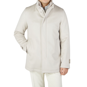 A luxurious man donning a Herno Cream Beige Water Repellent Cashmere Car Coat and white pants.