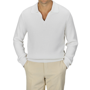 A man is wearing a Cream White Virgin Wool Knitted Pullover from Herno, paired with beige pants. The background is plain gray.