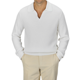 A man is wearing a Cream White Virgin Wool Knitted Pullover from Herno, paired with beige pants. The background is plain gray.