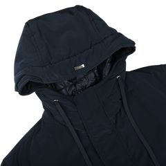 A close-up of the Dark Blue Nylon Technical Padded Jacket by Herno, showcasing drawstrings and a small metal brand logo on the hood, featuring wind- and water-repellent properties.