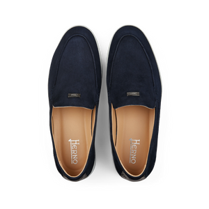 A pair of Herno dark blue suede slip-on loafers with a tan interior, displayed on a black background.