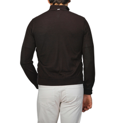 A person wearing a dark brown wool silk nylon padded jacket by Herno, paired with a black long-sleeve shirt and white pants, is shown from the back against a plain background.