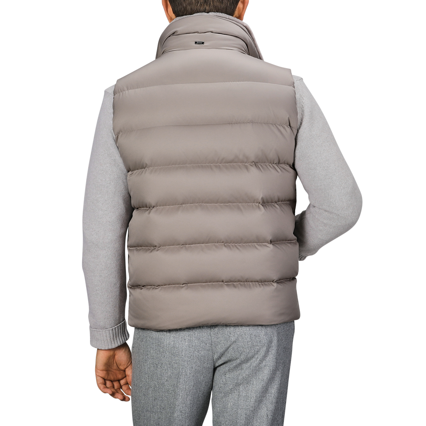 Man wearing a Herno Light Beige Nylon Goose Down Quilted Gilet and gray sweater, viewed from the back.