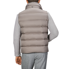 Man wearing a Herno Light Beige Nylon Goose Down Quilted Gilet and gray sweater, viewed from the back.