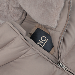 Close-up of a water-repellent Herno Light Beige Nylon Goose Down Quilted Gilet with a zippered pocket containing a folded scarf labeled "NO." The interior lining of the goose down gilet appears soft and fluffy.