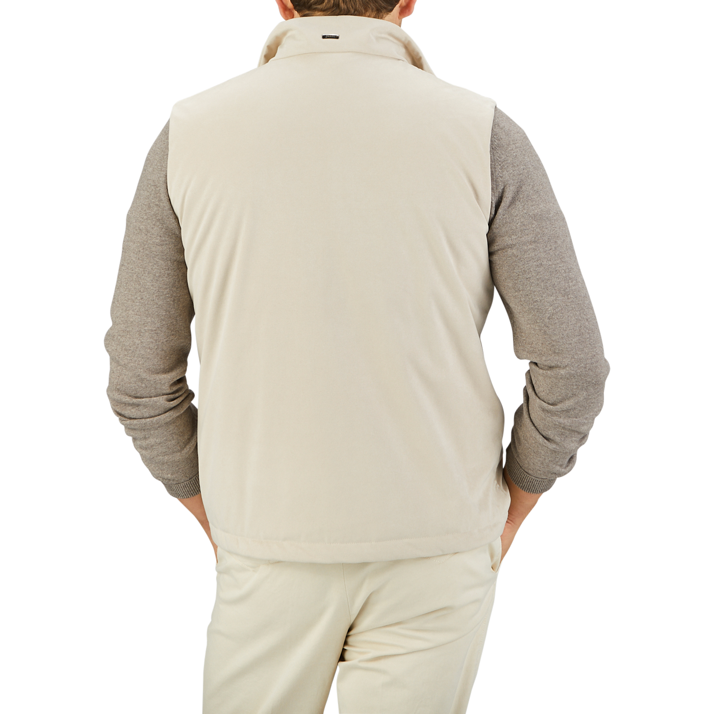 A person wearing a Herno Light Beige Suede Alcantara Zip Gilet over a gray long-sleeve shirt and light beige pants is photographed from the back against a plain background, showcasing a transitional style.