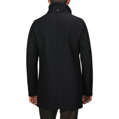 A person wearing a long, Navy Blue Diagonal Wool Padded Coat by Herno with the Herno Tech system is shown from the back, standing against a plain background.