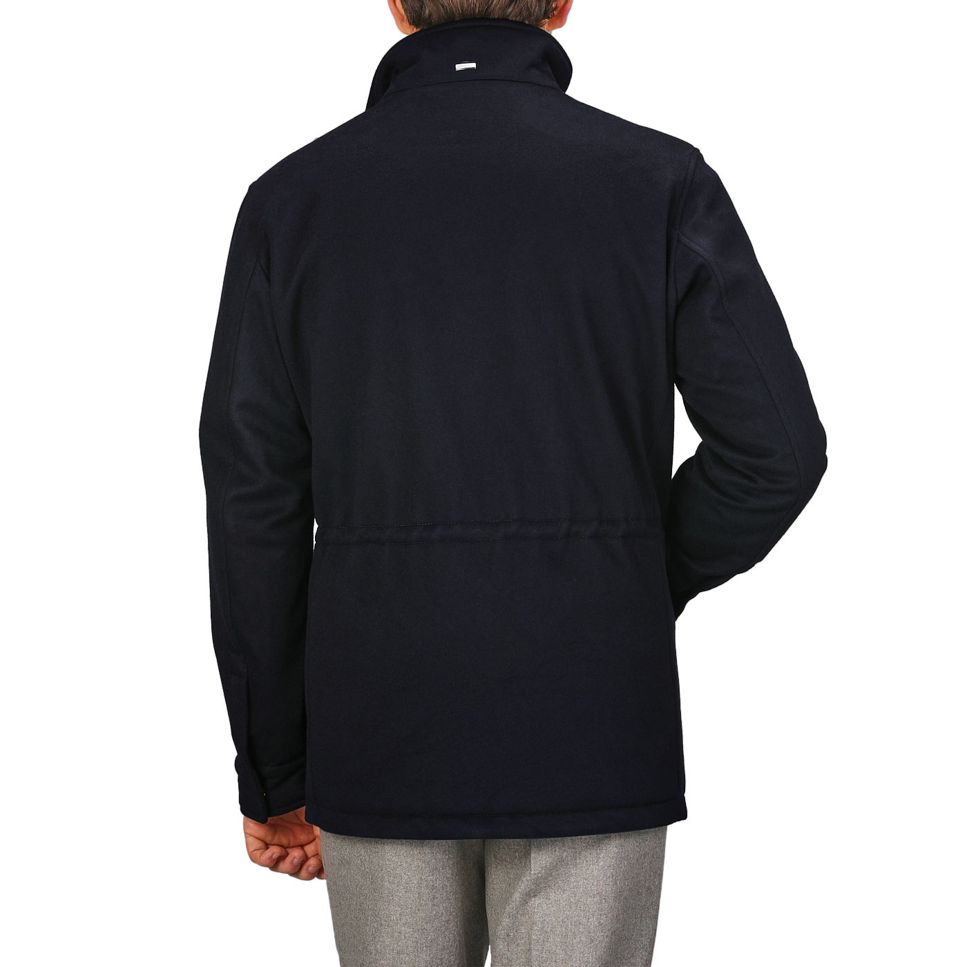 Rear view of a person wearing the Navy Blue Loro Piana Wool Field Jacket by Herno, featuring a high collar, paired with light gray pants, standing against a plain gray background.