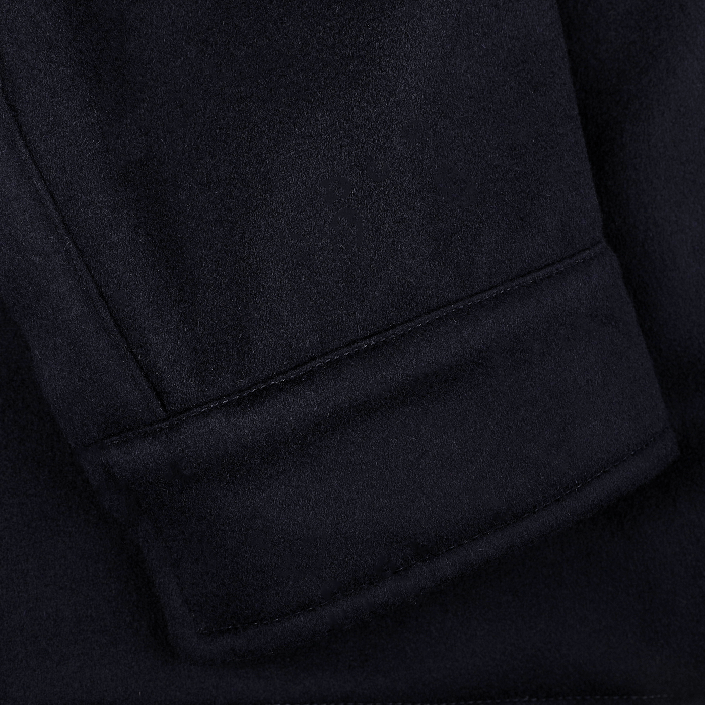 Close-up of a dark fabric sleeve with a neatly stitched hem and folded cuff, showcasing the precision typical of a Herno Navy Blue Loro Piana Wool Field Jacket. The design incorporates Rain System technology for enhanced weather resistance.