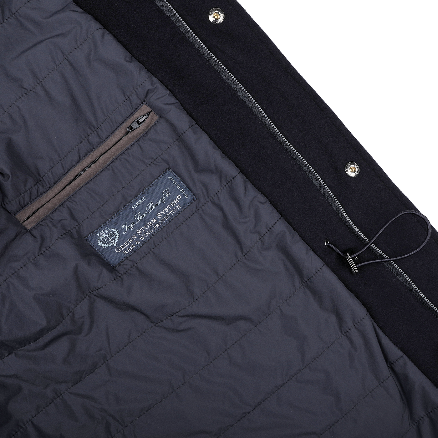 Close-up of the interior of a Navy Blue Loro Piana Wool Field Jacket by Herno, showcasing a zippered pocket, a blue label with text, and a black drawstring. The jacket's design seamlessly incorporates the innovative Rain System technology for enhanced protection.